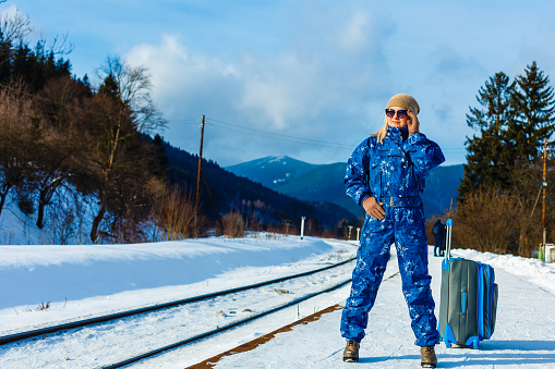 woman in ski suits stands near the railway
