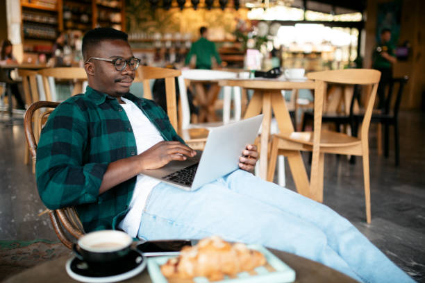 istock Side view of a young African American man working on his laptop 1273523949