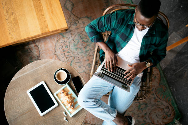 vista aérea de um jovem afro-americano trabalhando em seu laptop - above 21 - fotografias e filmes do acervo