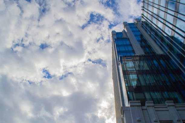 istock Part of a tall modern office building on the left against a cloudy sky 1273525172