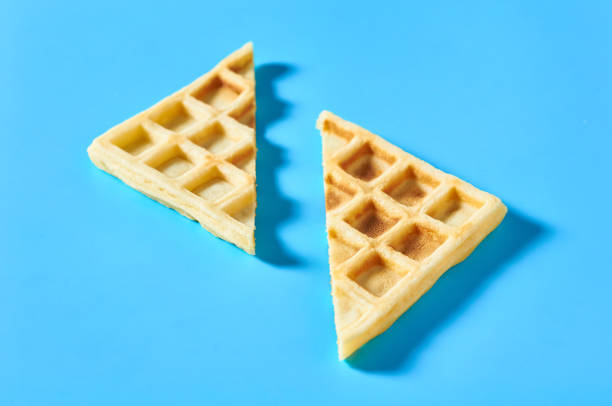 istock Cutted vanilla belgian waffles on blue background 1273529852