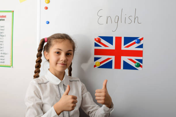 istock Cheerful little junior european learner showing thumbs up gesture, eager to study English language 1273529980
