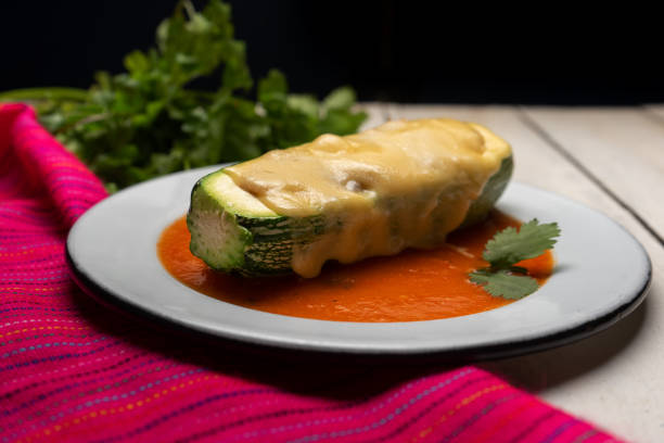 Traditional stuffed zucchini with tuna and melted cheese on white background