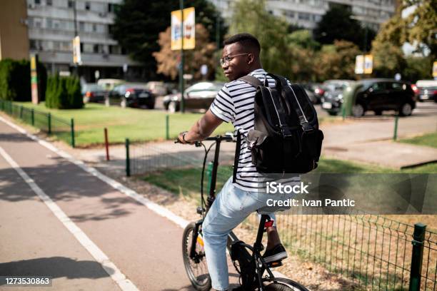 Rear View Of A Young African American Male Student Riding A Bicycle Stock Photo - Download Image Now