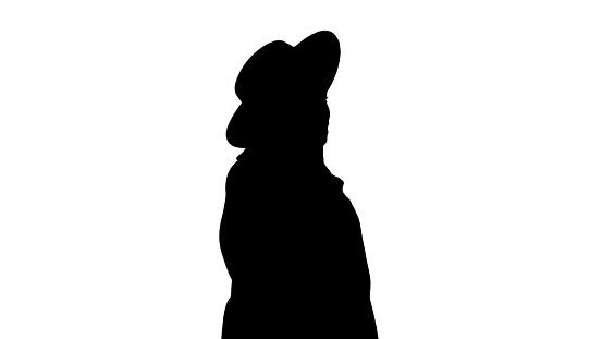 Medium shot. Side view. African american fashion girl in coat and black hat talking on the phone while walking, Alpha Channel Professional shot in 4K resolution. 046. You can use it e.g. in your medical, commercial video, business, presentation, broadcast