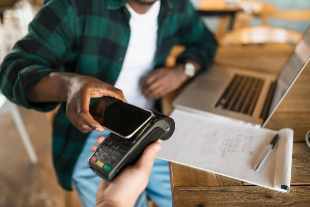 istock Young African American man paying with his smart phone 1273535207