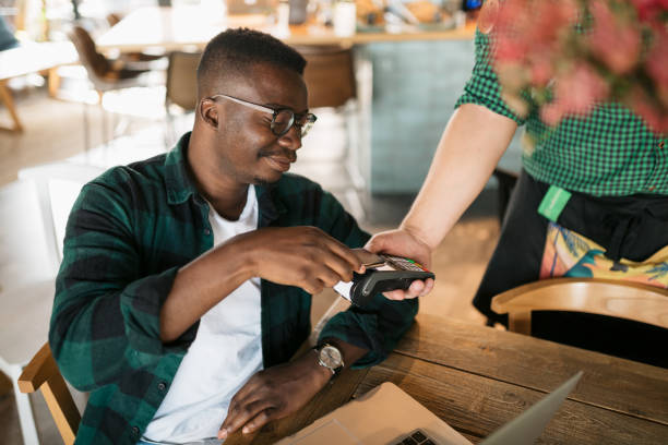 istock Young African American man paying with his smart phone 1273535220
