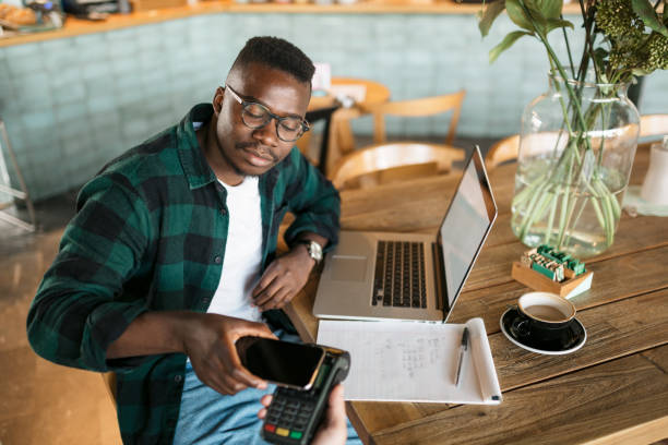 istock Young African American man paying with his smart phone 1273535267