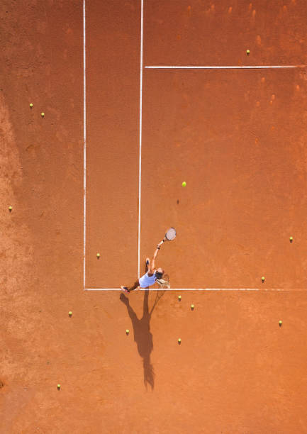 healthy lifectyle. a young girl plays tennis on the court. the view from the air on the tennis player. dirt court. sport background. aerial view from drone. - tennis ball tennis racket tennis vertical imagens e fotografias de stock