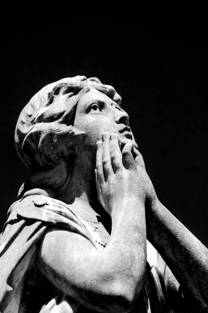istock Black and white Praying Angel, old statue of angle, black background with copy space 1273536471