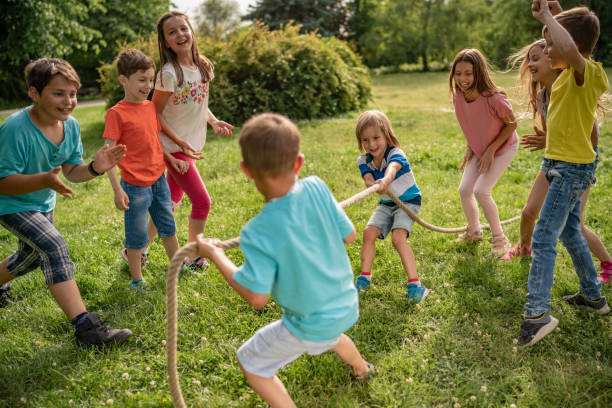 istock Playful kids are pulling a rope in park 1273537134