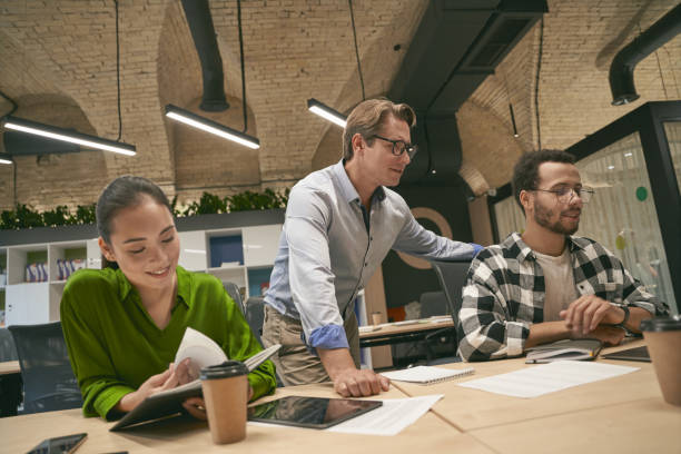 istock Multicultural business people working on project together in the modern office, confident caucasian male boss or executive communicating and sharing ideas with diverse team 1273537469
