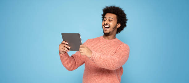 istock Happy African Man Holding Tablet 1273543334