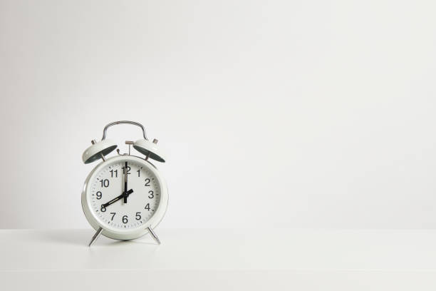 istock Vintage white alarm clock on a design white background with space for copy with the time on eight oclock 1273543906