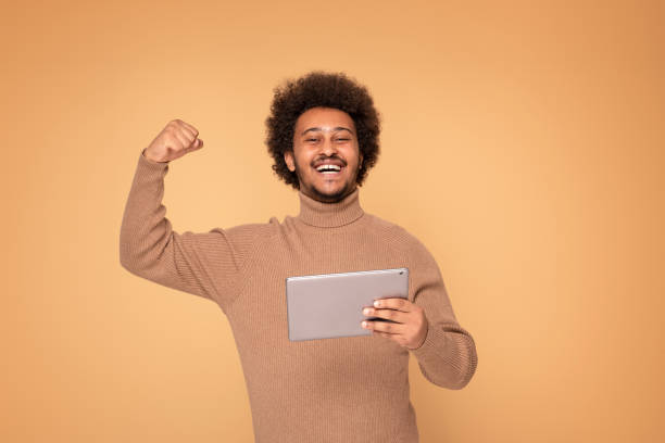 istock Happy African Man Holding Tablet 1273544231