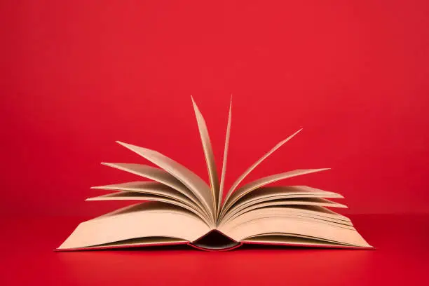 Photo of Open book with pages on a red background