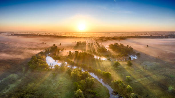 istock Mystical morning river, the sun's rays shine through the fog. 1273545945