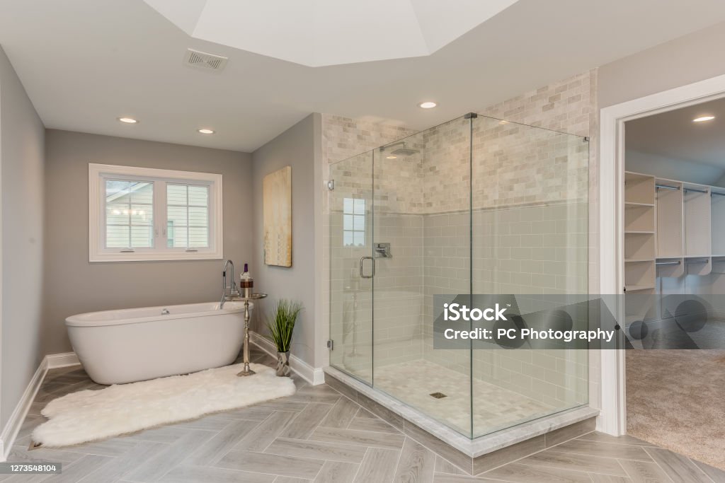 Master bathroom with freestanding tub and large all glass shower Patterned flooring with beautiful tray ceiling Bathroom Stock Photo