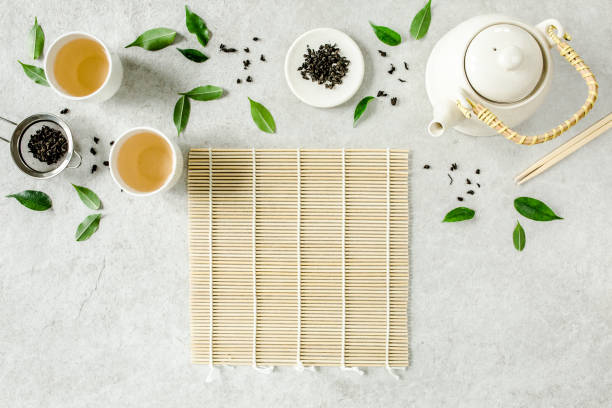 istock Herbal tea with two white tea cups and teapot, with green tea leaves. Flat lay, top view. Tea concept 1273549264