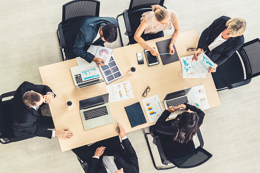 Business people group meeting shot from top view in office . Profession businesswomen, businessmen and office workers working in team conference with project planning document on meeting table .