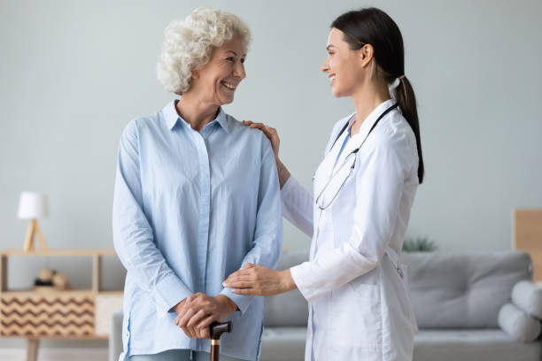 istock Caring young nurse helping old lady patient 1273555385