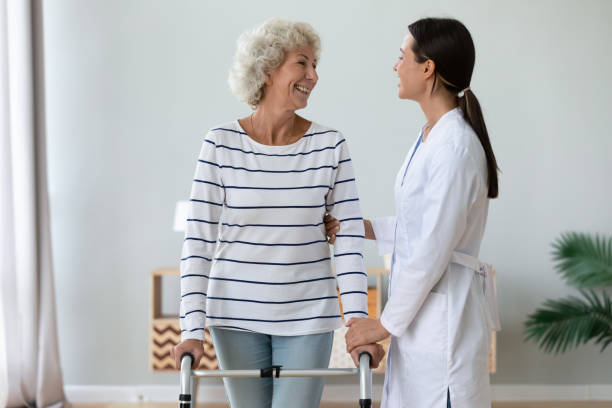 istock Positive old lady with walker talk with caring nurse 1273555407