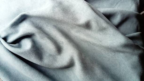 istock A velvety dense fabric for curtains of gray color, randomly folded by beautiful smooth waves. Natural daylight 1273555689