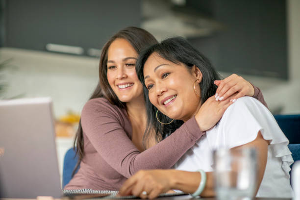 istock Mother and daughter video chatting together from home 1273555906