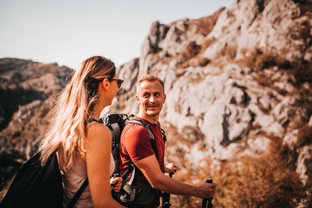 istock Backpackers happy young couple hiking with sticks 1273556776