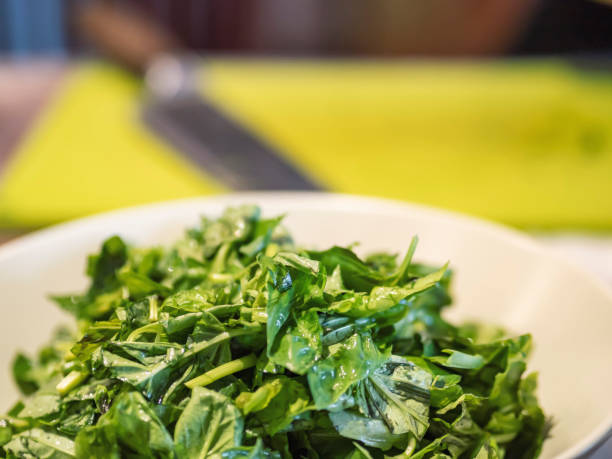Fresh basil leaves are chopped and placed in a bowl