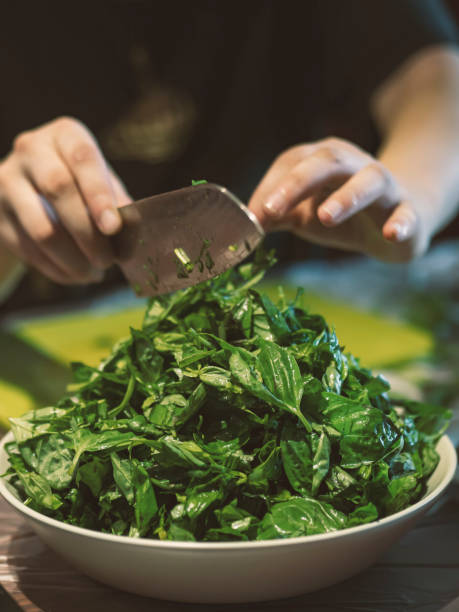 istock Young woman is cutting basil leaves into pieces 1273557574
