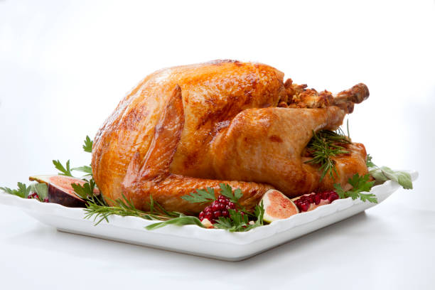 Traditional Roasted Turkey on White Garnished traditional roasted turkey, garnished with fresh figs, pomegranate, and herbs. On white background. cooked stock pictures, royalty-free photos & images