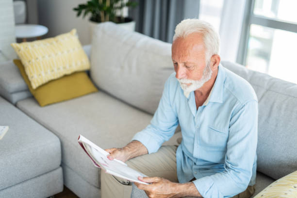 Senior man reading a magazine at home.