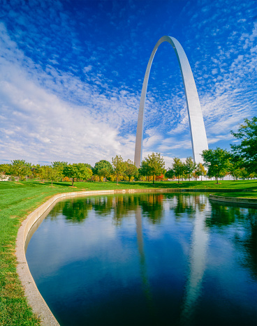 Grass, water and autumn trees surround the Gateway Arch in Saint Louis, Missouri.