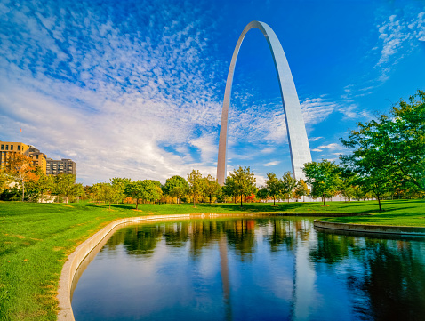 Grass, water and autumn trees surround the Gateway Arch in Saint Louis, Missouri.