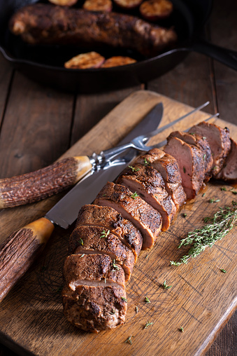 Roasted Pork Tenderloin Sliced on a Cutting Board