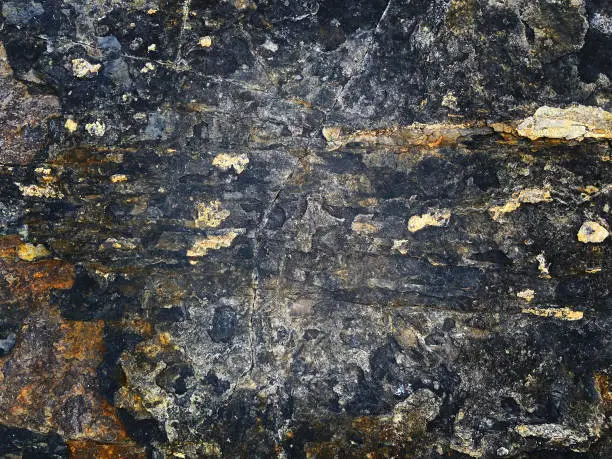 Stone texture with crack. Rusty, black, yellow colors background