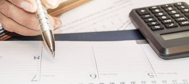 istock Financial data analyzing. Counting on calculator. Hand with pen on calculator 1273568490