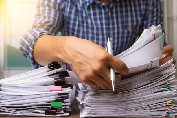 istock Business man hand pick up Stack overload document report paper with colorful paperclip, business and paperless concept. 1273572632