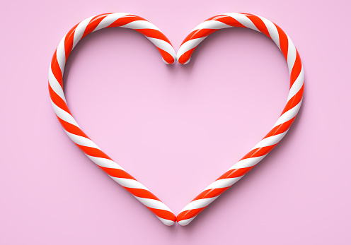 Two classic red and white christmas candy cane in shape of heart on pink background. Frame with copy space for candy bar. Flat lay 3D illustration and 3D rendering.