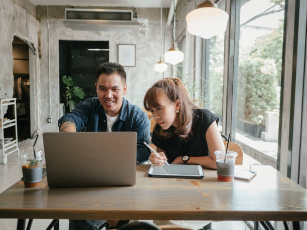 istock Asian couple talking about business in cafe. 1273578666