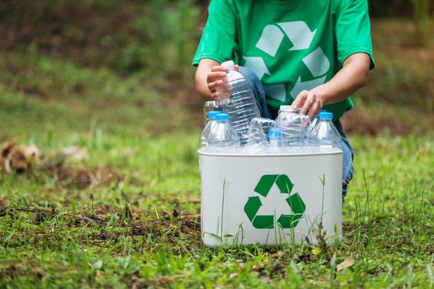 istock A woman collecting and putting plastic bottles into a recycle bin 1273580141