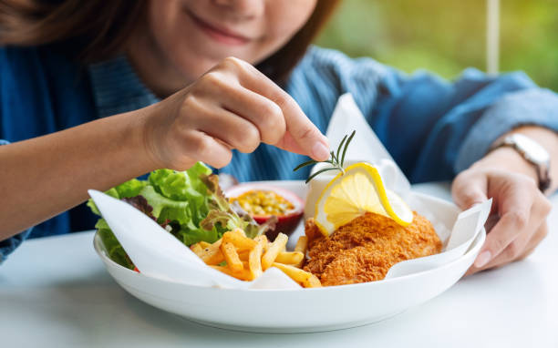 a female chef cooking and decorating a dish of fish and chips