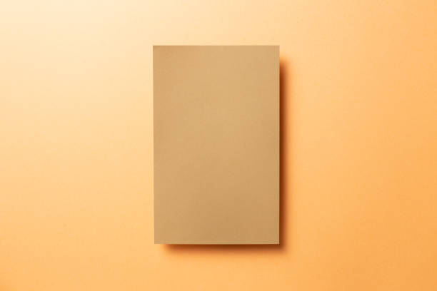 istock Kraft brown memo pad, empty paper on orange background. top view, copy space 1273581991