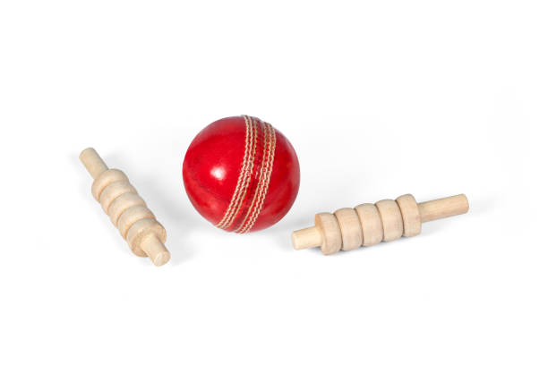 cricket-ball und bails, roter ball und weißer ball isoliert auf weißem hintergrund, studio-schuss ausschnitt - kricketball stock-fotos und bilder