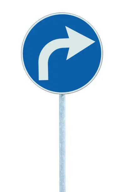 Right turn ahead road sign, blue round isolated roadside traffic signage, white arrow icon frame, grey pole post, vertical closeup