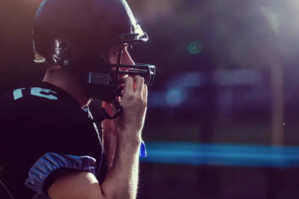 boy taking his football helmet off after a game