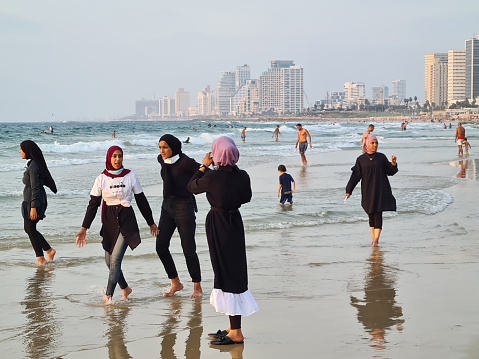 Tel Aviv, Israel - September 18, 2020: Muslim women relax at sea beach before lockdown starts.