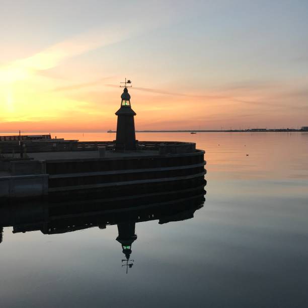 istock Old lighthouse end of pier with sunrise in background 1273597521