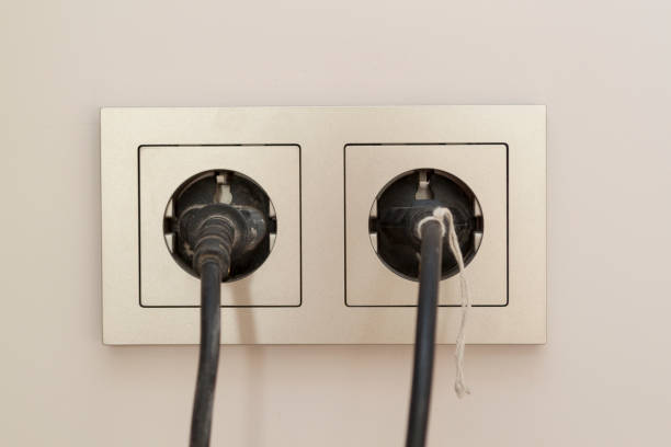istock two black plugs are plugged into a double electrical outlet with a frame 1273597662